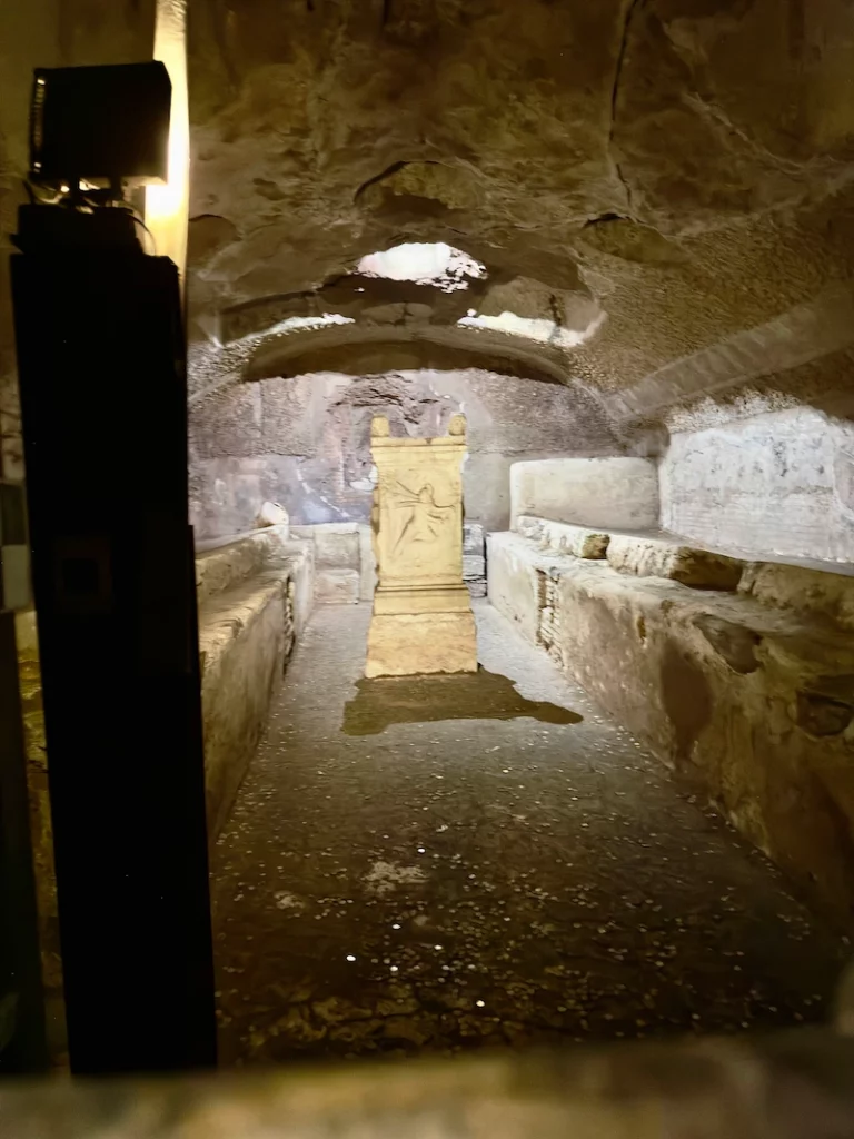 Vista do Mitreu de São Clemente, com o altar e bancos laterais, no subsolo da basílica em Roma