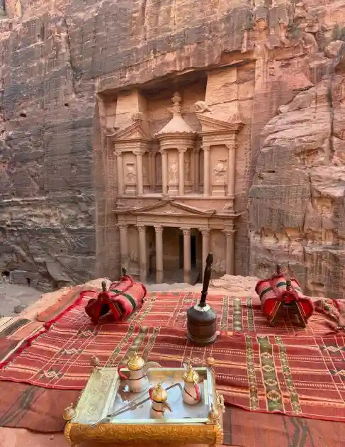 Vista do Tesouro de Petra a partir de um miradouro com tapetes e chá beduíno
